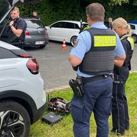 Zwei Polizeibeamte kontrollieren ein Fahrzeug an der belgischen Grenze