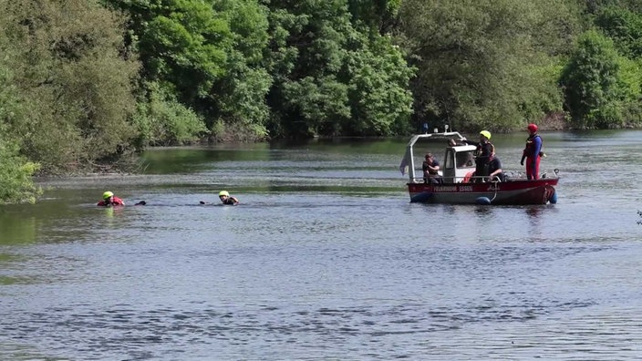 Taucher neben einem Boot auf der Ruhr im Einsatz