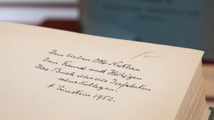 Ein Blick auf eine Buchseite mit der Widmung, die Albert Einstein geschrieben hat