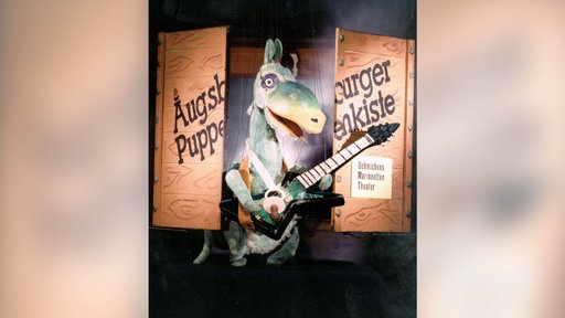 Urmel aus dem Eis und Kiste mit der Aufschrift "Augsburger Puppenkiste"