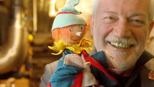 Klaus Marschall zeigt im Fundus des Museums "Die Kiste" seinen ersten Kasperl, eine Handpuppe noch ohne Fäden