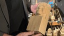 Eine Hand hält ein bearbeitetes Stück Lindenholz