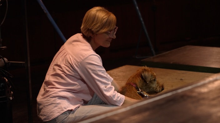 Hund und Frau versinken im Orchestergraben auf Bühne