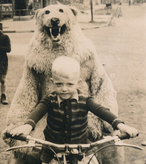 Ein Kind sitzt auf einem Motorrad. Hinter dem Jungen sitzt ein Mensch als Eisbär verkleidet.