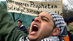 "Wer unseren Propheten beleidigt, beleidigt uns alle" steht auf einem Transparent von Demonstranten