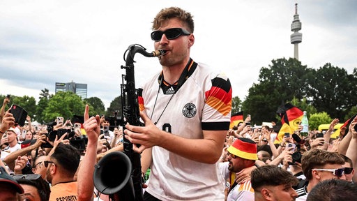 Mann mit Saxofon in einer Fan-Menge bei der Fußball-EM 2024