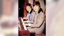 Paul McCartney und John Lennon sitzen gemeinsam am Klavier und lächeln Richtung Kamera (ca. 1964)