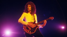 Brian May spielt Gitarre auf der Bühne