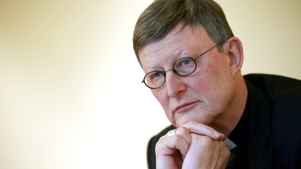 Ein Mann, der Kölner Erzbischof Rainer Maria Woelki, schaut an der Kamera vorbei, dabei stützt er seine Hände auf seinem Kinn auf