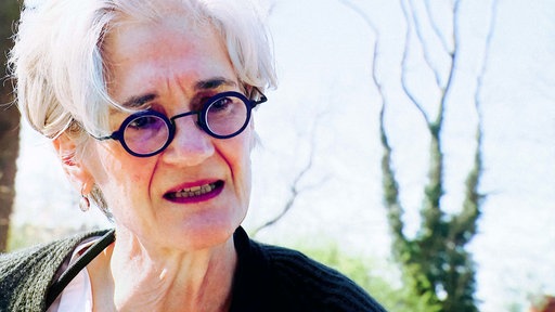 Katrin Hesse im Interview. Sie hat kurze graue Haare und trägt eine Brille.