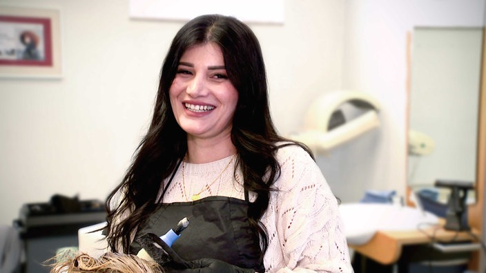 Miryam Suleiman steht im Friseursalon in Ahlen und lacht