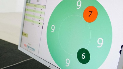 Eine digitale grüne Zielscheibe zeigt die Ziffern 9,7 und 6 an. 