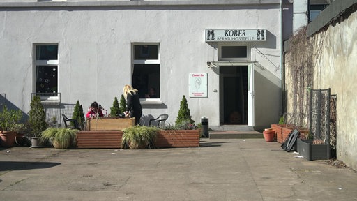Die schlichte graue Fassade des Café "Come In" in einem Hinterhof in der Dortmunder Nordstadt, über der Tür hängt das Schild "Kober Beratungsstelle"