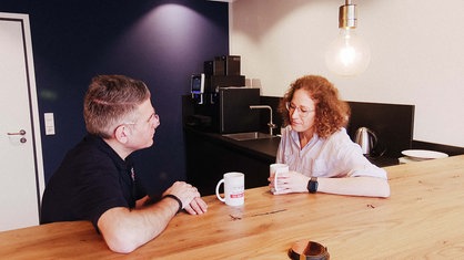 v. l. Michael Hendricks und Nadine Schering. Sie sitzen an einem Tisch.