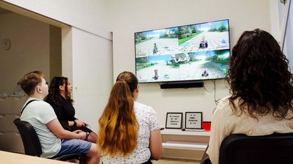 Vier Personen spielen Mario Kart.