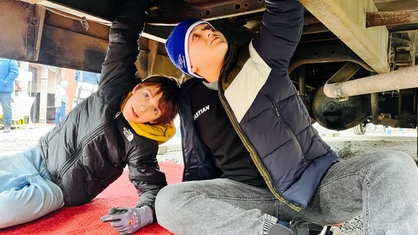 Juri Abeler und Sebastian Matei schrauben gemeinsam am Bus