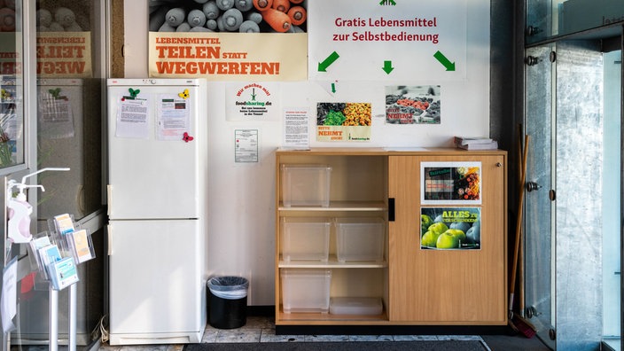 Bei der Katholischen Hochschulgemeinde in Köln stehen ein Kühlschrank und ein Regal, um Lebensmittel zu teilen.