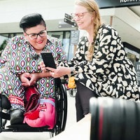 Zwei Frauen schauen gemeinsam Fotos auf einem Handy an. 
