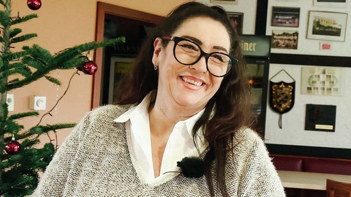 Tanja Hoffmann lächelt. Links neben ihr ein Weihnachtsbaum.