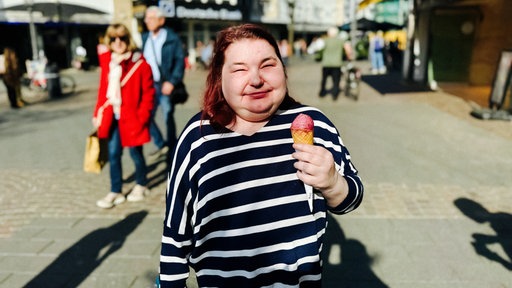 Eine Frau steht mit einem Eis in der Hand in der Siegburger Innenstadt
