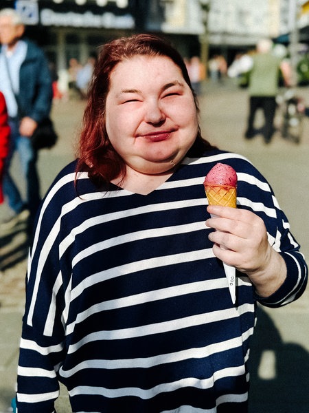 Eine Frau steht mit einem Eis in der Hand in der Siegburger Innenstadt