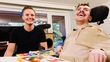 Zwei Junge Männer lachen in die Kamera.
