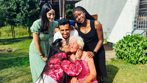 Talel Jouini, Horline Bognou Takuete, Ons Maiti und Ghada Abbassi und Vermieterin Christel Varga vor einem Haus im Garten.