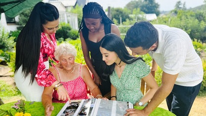 Talel Jouini, Horline Bognou Takuete, Ons Maiti, Ghada Abbassi und Christel Varga schauen in ein Fotoalbum.