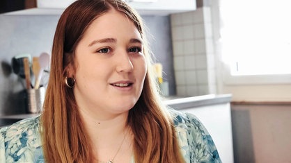 Chiara Orlowski, eine junge Frau mit dunkelblonden Haaren und blau-grün-weißem Oberteil