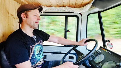 Ein Mann sitzt im Auto hinter dem Lenkrad