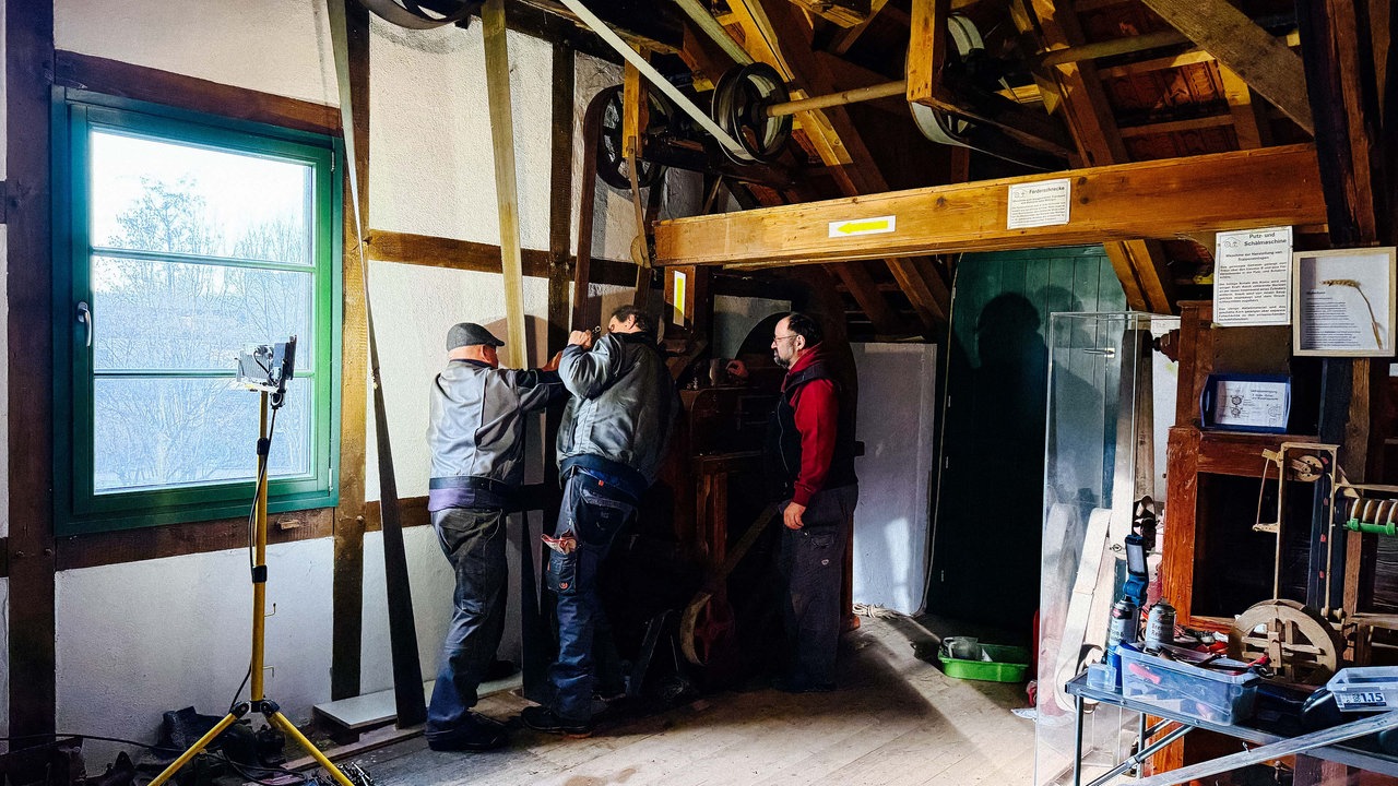 Drei Männer werkeln in einer alten Mühle in Meckenheim
