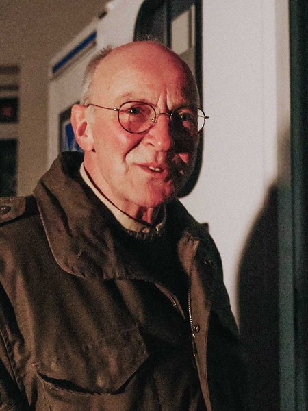 Ehrenamtler Klaus Butterweck steht vor einem Krankentransporter am Wuppertaler Hauptbahnhof