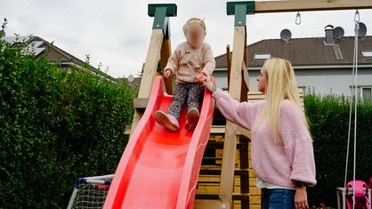 Julia Korbach und ihre Tochter Nele beim spielen auf einer Rutsche.
