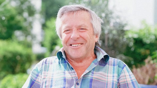 Josef Kremer trägt ein kariertes Hemd und lächelt freundlich