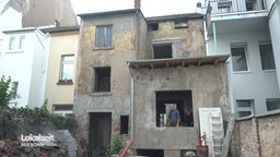 Rückansicht eines zwei geschossigem heruntergekommenen Hauses ohne Fenster