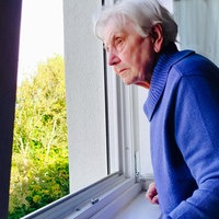 Anneliese Götte schaut aus einem Fenster ihres Elternhauses.