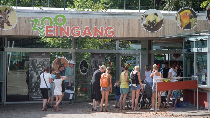 Menschen versammeln sich vor dem Eingang des Allwetterzoos Münster.