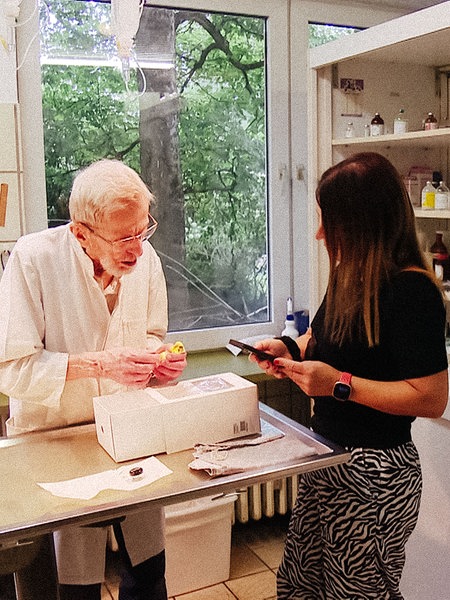 Diethelm Graf von Plettenberg hält einen gelben Wellensittich in der Hand. Neben ihm steht eine Frau mit braunen Haaren.
