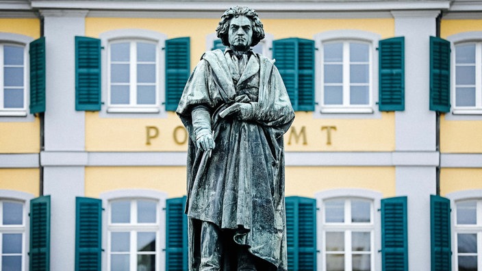 Postamt am Bonner Münsterplatz. Mittig eine Statue von Beethoven.