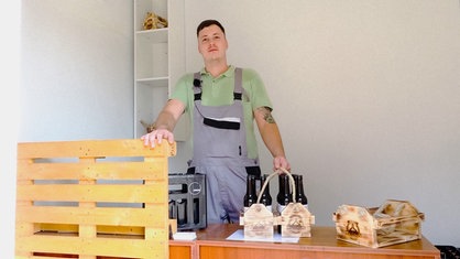 Philipp Löffler steht in seinem kleinen Hofladen hinter dem Tresen, vor ihm einige Flaschen Bier.