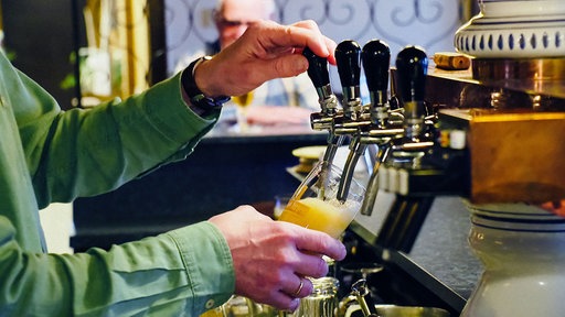 Heiner Jürgens zapft Bier in ein Glas.