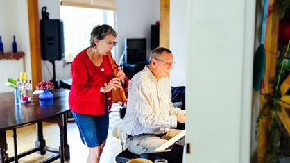 Barbara Knappe und Harald Maxa machen gemeinsam Musik. Barbara spielt Flöte, Harad sitzt am Klavier.
