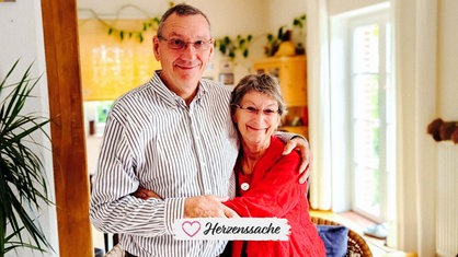 Barbara Knappe und Harald Maxa stehen Arm in Arm nebeneinander und lächeln in die Kamera.