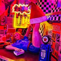 Dekoartikel in einer Bar: eine Pin-Up Figur, Modellautos und eine Minizapfsäule.