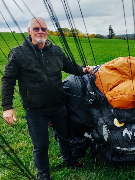 Jürgen Jansen (rechts) und Hans Schneider (links) stehen auf einer grünen Wiese und halten einen orange-schwarzen Stoff mit dem Gesicht eines Gorillas.