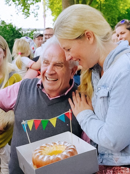 Eisverkäufer Donato Grella lacht und wird von einer blonden Frau gratulierend gedrückt.