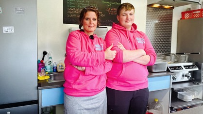 Noel Schnieders und Mutter Barbara in dem Imbisswagen. Beide tragen einen pinken Pullover 