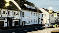 Eine Straße mit Häusern, auf der Autos fahren