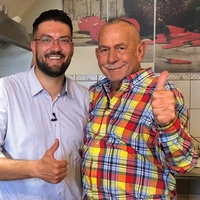 Zwei Männer, die den Daumen hoch zeigen und in die Kamera lächeln