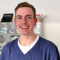Portraitaufnahme von Julian Mergler. Er trägt einen blauen Kasack. 